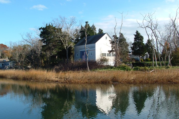 a small pond in front of a lake surrounded by a body of water